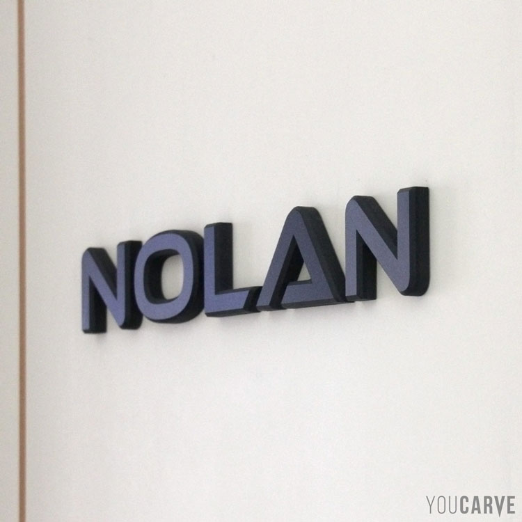 Prénom enfant/bébé (Nolan), lettres découpées en PVC expansé noir ép. 10 mm avec chanfreins, fixation double-face sur porte de chambre.