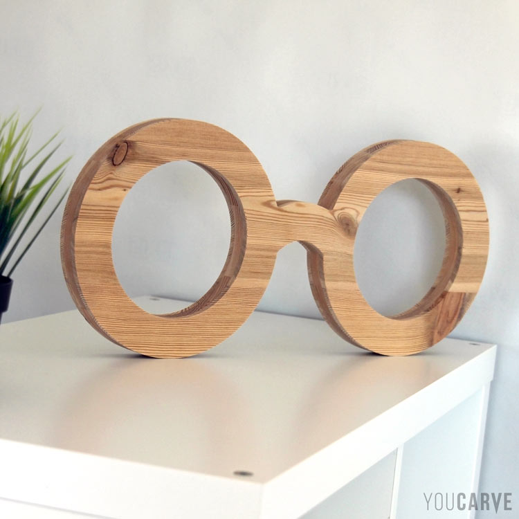 Décoration boutique opticien, forme de lunettes géantes en bois, posées sur meuble ou sur comptoir.