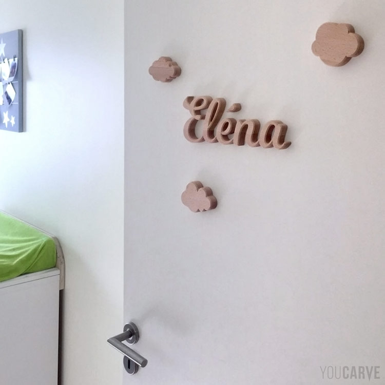 Prénom Eléna en lettres découpées en bois (hêtre ép. 19 mm) fixation mousse double-face sur porte de chambre d'enfant.