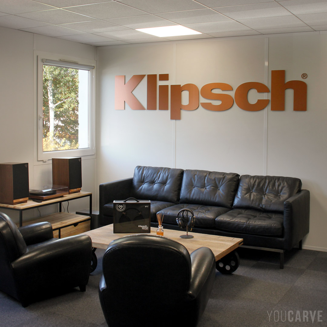 Réalisé par Klipsch France (fabricant d’équipements de sonorisation) : logo mural en relief, découpe en aluminium-dibond brossé cuivré, épaisseur 3 mm, fixation mousse-double-face.