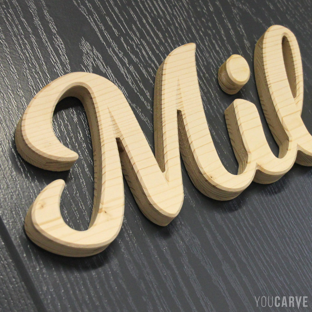 Mila, prénom d’enfant en bois, lettres découpées en bois (épicéa épaisseur 19 mm), fixation mousse double-face.