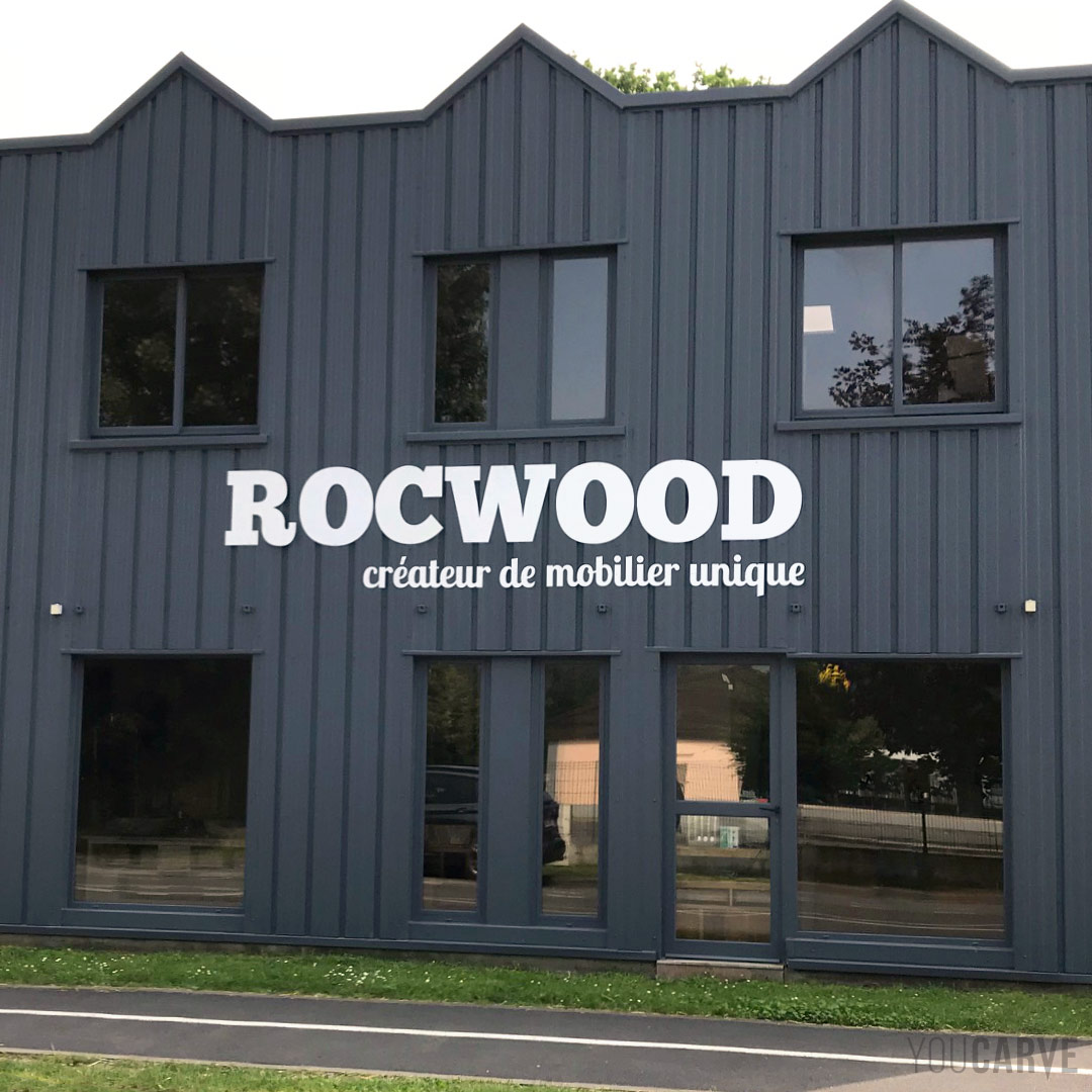 Réalisé par Rocwood : enseigne magasin de mobilier de création à Lamorlaye, lettres découpées en aluminium-dibond laqué blanc mat (épaisseur 3 mm).