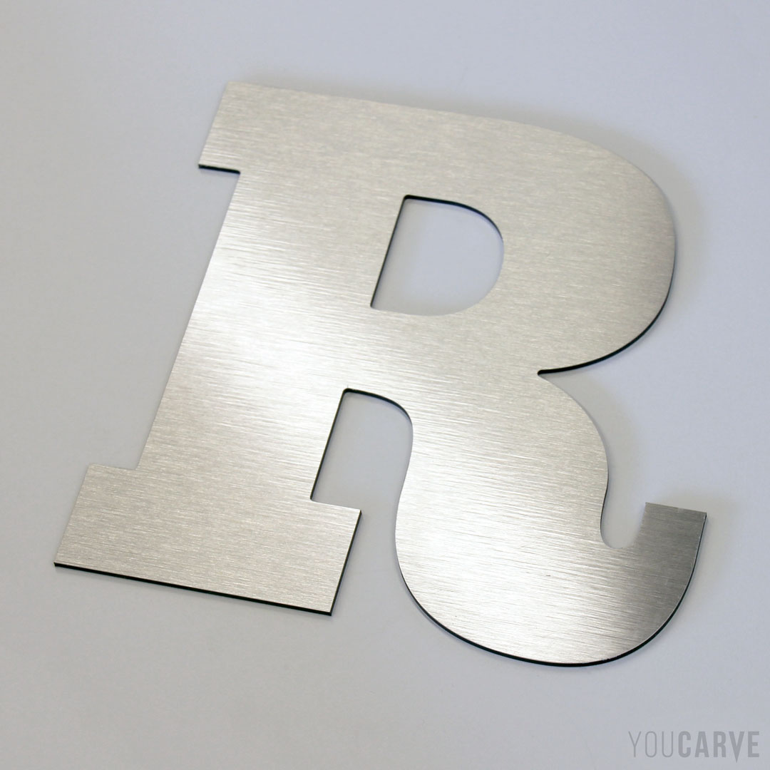 Lettre R découpée en dibond aluminium brossé (épaisseur 3 mm), pour l’enseigne et la signalétique.