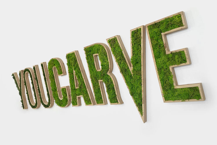 Logo mural Youcarve en bois avec insertion de mousse végétale.